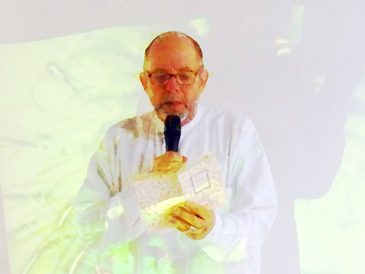 Pierre Joris reading, white shirt on white background